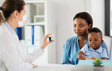 Image showing doctor in mask and woman with son at clinic