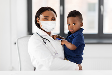 Image showing doctor in mask with baby patient at clinic