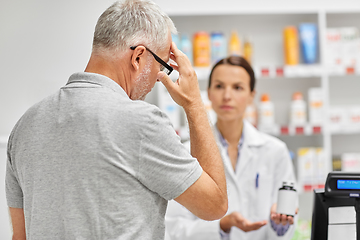 Image showing pharmacist and old man with medicine at pharmacy