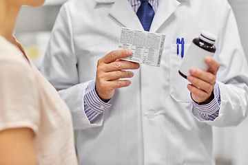 Image showing male apothecary and woman with drug at pharmacy