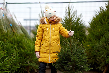 Image showing little girl choosing christmas tree at market