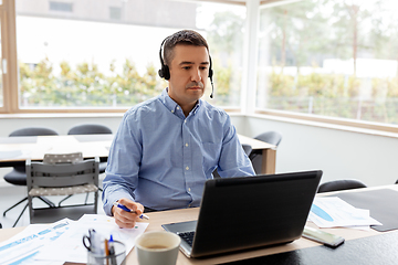 Image showing man with headset and laptop working at home