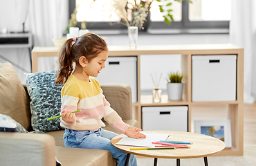 Image showing little girl drawing with coloring pencils at home