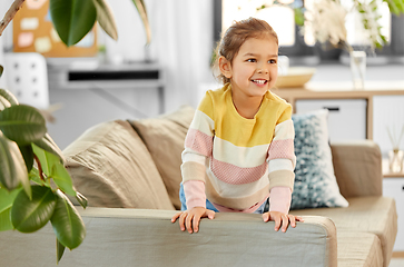 Image showing happy smiling little girl on sofa at home