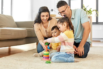 Image showing happy family playing with pyramid toy at home