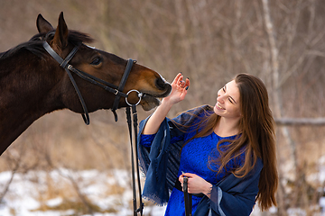 Image showing Happy girl playing with horse, horse shows teeth, closeup portrait