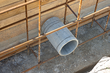 Image showing Laying a sleeve for communications during the construction of a strip foundation