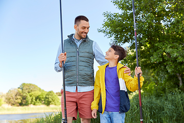 Image showing happy smiling father and son fishing on river