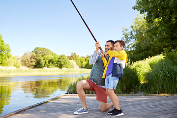 Image showing happy smiling father and son fishing on river