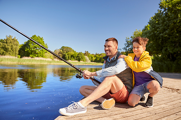 Image showing happy smiling father and son fishing on river