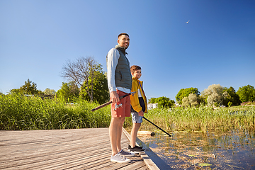 Image showing happy smiling father and son fishing on river