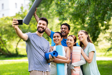 Image showing happy people with yoga mats taking selfie at park