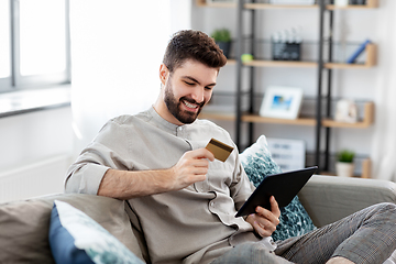 Image showing man with tablet computer and credit card at home