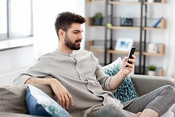 Image showing young man with smartphone at home