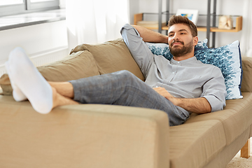 Image showing young man sitting on sofa at home