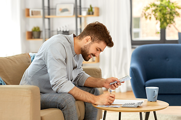 Image showing man with money and calculator filling papers