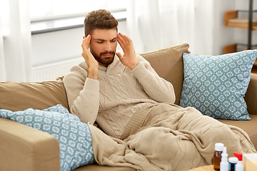 Image showing unhappy man suffering from head ache at home