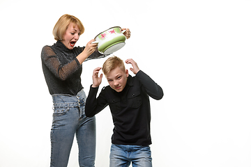 Image showing Mom hits her son with a pan because he refuses to eat home-cooked food