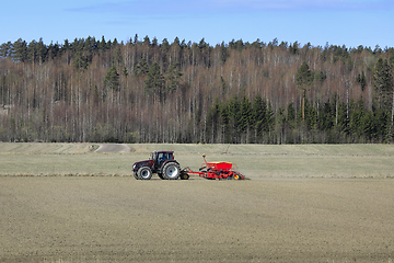 Image showing Rural Landscape with Tractor and Seed Drill in Field