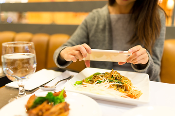 Image showing Woman taking photo on her dinner