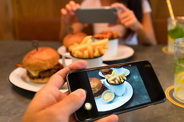 Image showing Taking photo on cellphone in restaurant