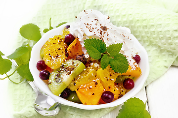 Image showing Salad fruit with cranberries in bowl on light board