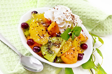 Image showing Salad fruit with cranberries in bowl on white wooden board