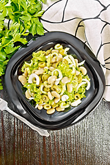 Image showing Salad of beans and olives in plate on dark board top