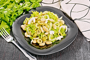 Image showing Salad of beans and olives in plate on dark board