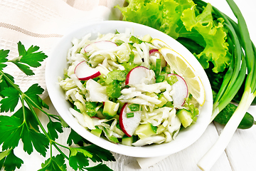 Image showing Salad of cabbage with radish in plate on light board