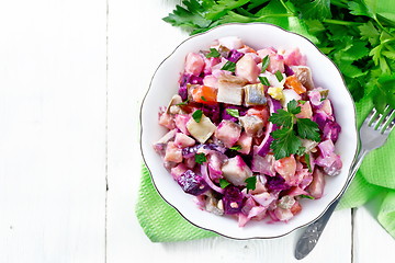 Image showing Salad with herring and beetroot in bowl on napkin top