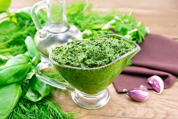 Image showing Sauce of spicy greens in gravy boat on old board