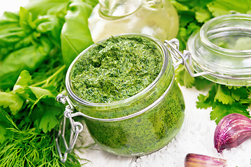 Image showing Sauce of spicy greens in jar on light board