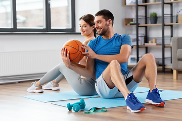 Image showing happy couple exercising with ball at home