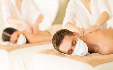 Image showing couple in masks having back massage at spa