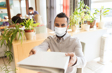 Image showing creative male office worker in mask with folder