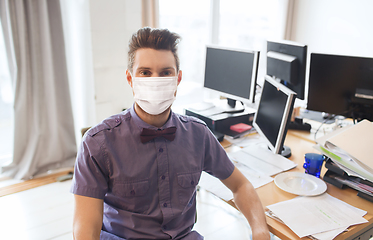 Image showing male office worker in mask with computers