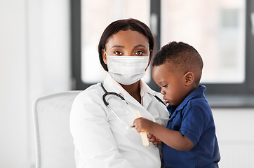 Image showing doctor in mask with baby patient at clinic