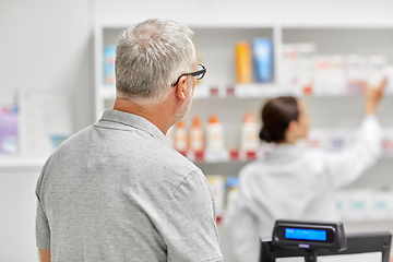 Image showing senior man buying medicine at pharmacy
