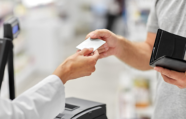 Image showing close up of hand giving bank card to pharmacist