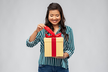 Image showing happy asian woman opening gift box