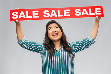 Image showing happy smiling young asian woman with sale banner