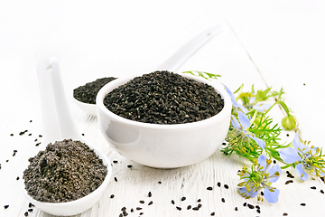 Image showing Seeds of black cumin in bowl on wooden board