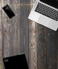 Image showing Laptop, tablet and phone set mockup on a wooden background. 3D r