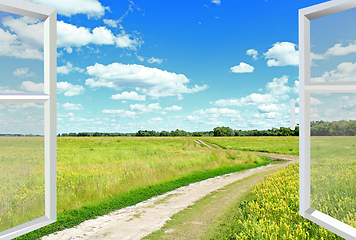 Image showing View to clouds meadow and country road from window