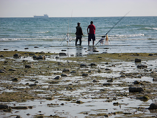 Image showing Fishermen on the seashore.