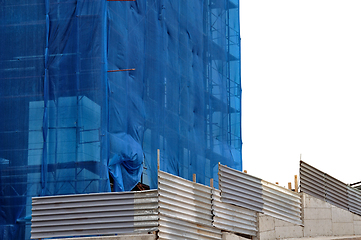 Image showing building covered with construction debris netting