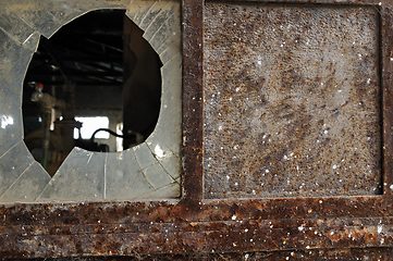 Image showing rusty factory door and smashed glass