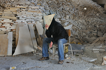 Image showing man under pile of broken marble