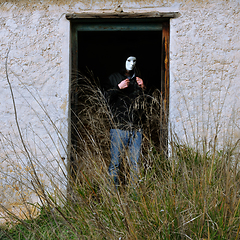 Image showing masked figure and broken door